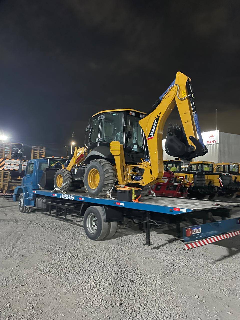 Guincho Japinha transportando retroescavadeira SANY na plataforma à noite